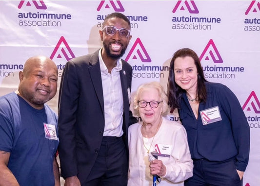 four patient advocates standing at varying heights in front of an Autoimmune Association banner.
